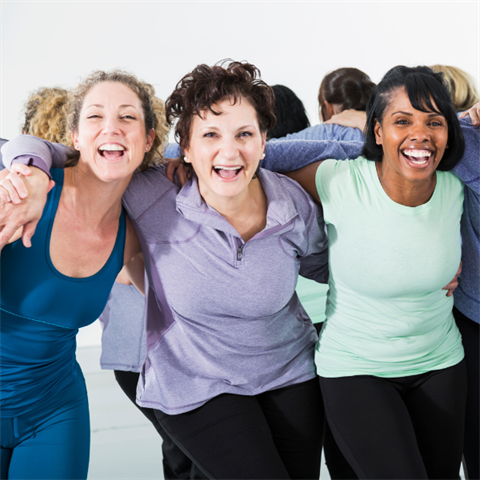 group of women linking arms in fitness clothing