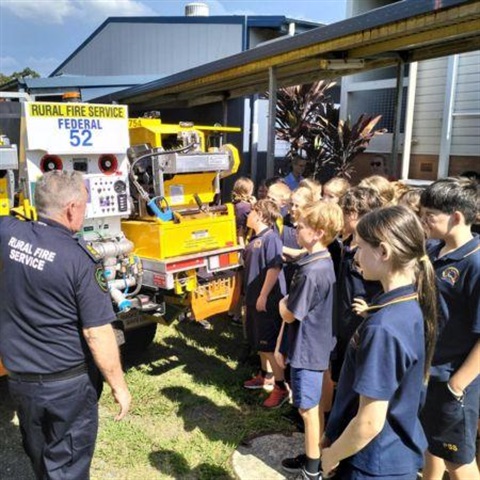 Ian Pike of the Rural Fire Service shows Pomona State School students around a fire truck.